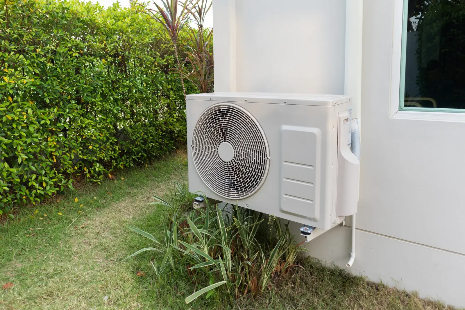 Unité extérieure de pompe à chaleur air-eau installée le long d'une maison